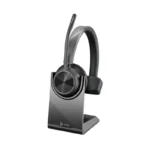 Poly Voyager 4310 UC USB-C headset with upright boom microphone resting on a black desktop charging stand.